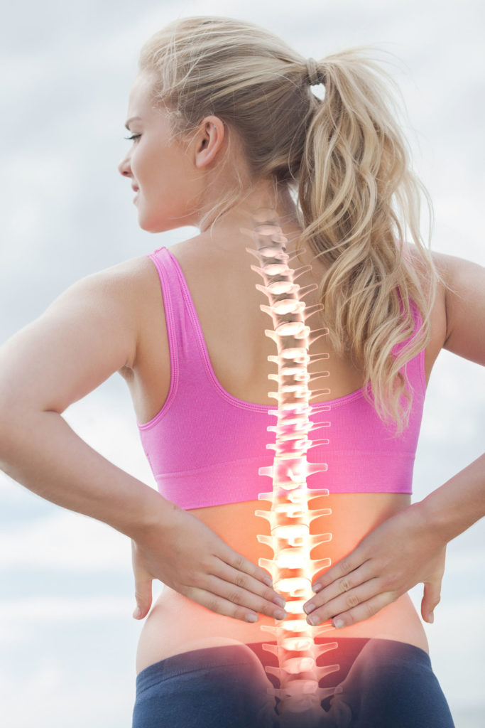 digital composite of highlighted spine of woman with back pain
